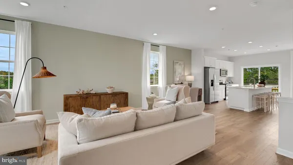 a living room with furniture white walls and kitchen view
