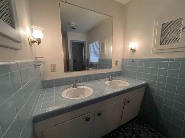 a bathroom with a granite countertop sink a mirror and a shower