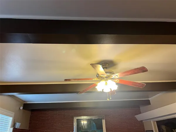 a view of a room with a ceiling fan and wooden floor