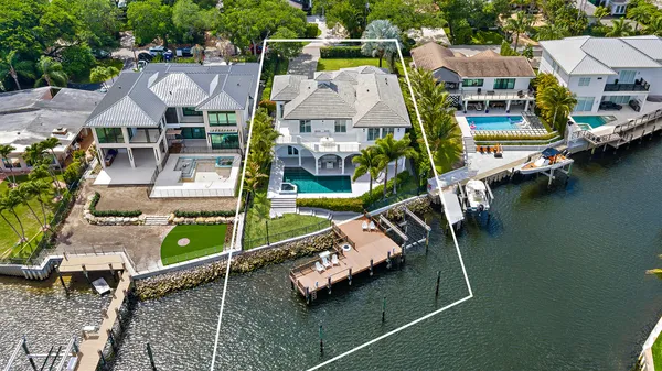 an aerial view of a house with swimming pool and outdoor seating