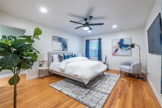 a bedroom with a bed dresser and a potted plant