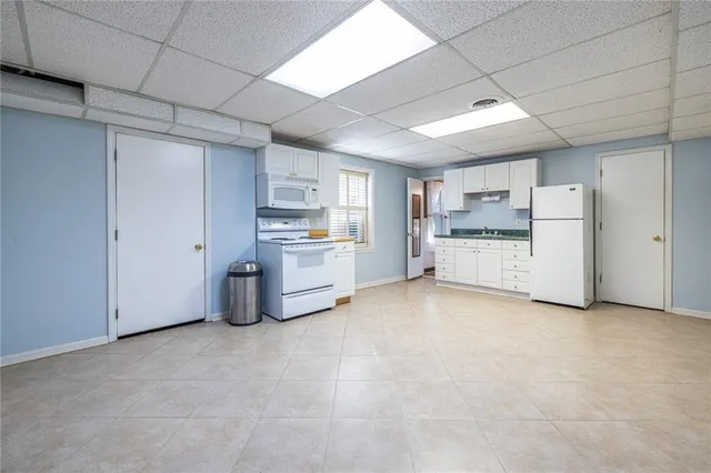 a view of a kitchen with refrigerator and a stove top oven