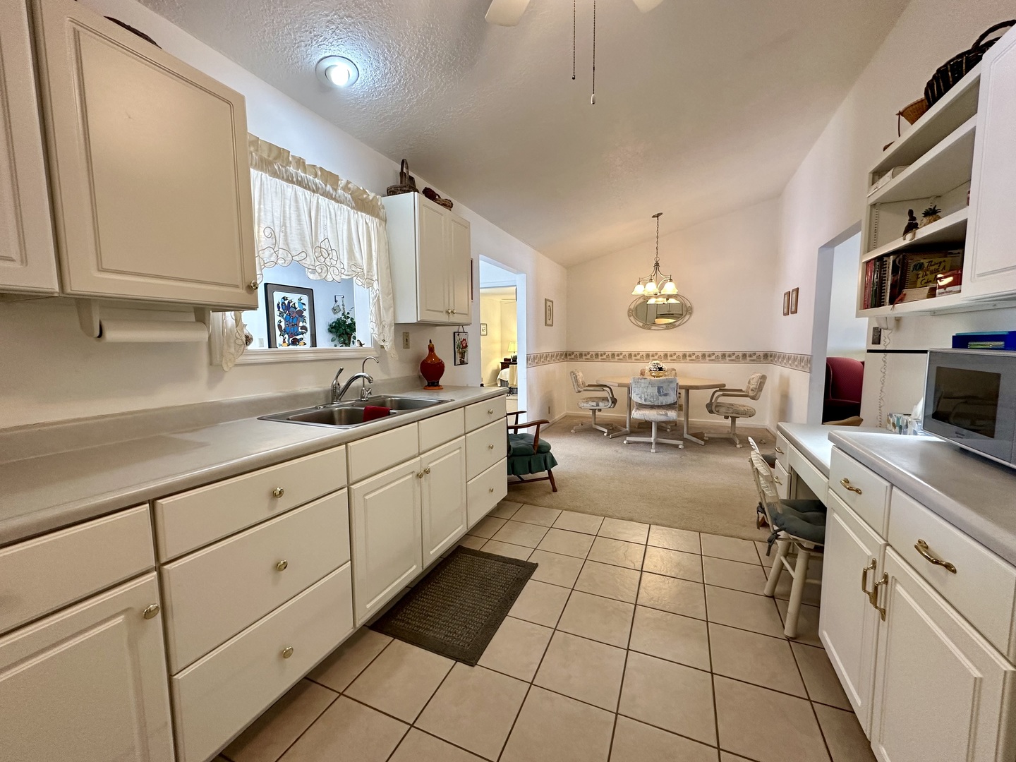 8752 Wagon Trail Road Clinton, IL 61727 - Photo 11 of 19 a kitchen with sink cabinets and living room view