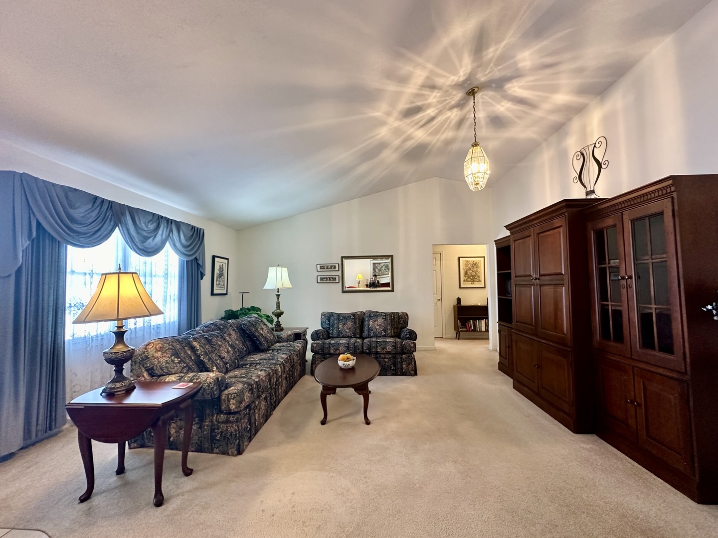 8752 Wagon Trail Road Clinton, IL 61727 - Photo 3 of 19 a living room with furniture a chandelier and a flat screen tv