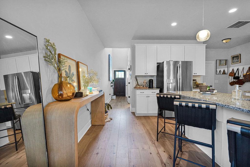 1201 Shiva Boulevard Winder, GA 30680 - Photo 41 of 84 a kitchen with stainless steel appliances a refrigerator a stove a sink dishwasher and white cabinets with wooden floor