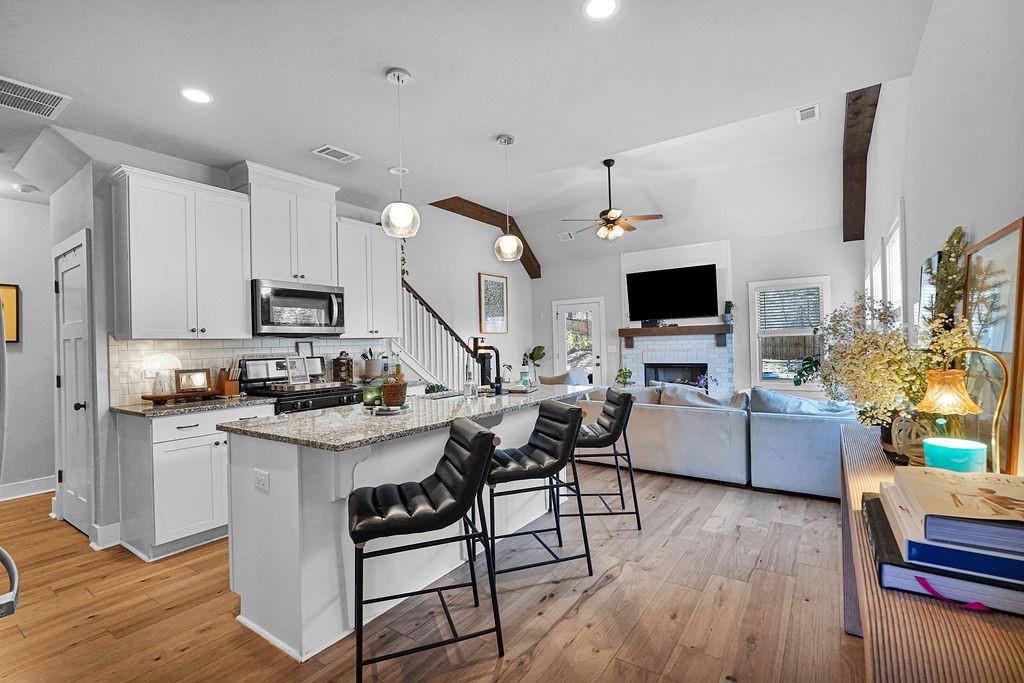 1201 Shiva Boulevard Winder, GA 30680 - Photo 50 of 84 a kitchen with stainless steel appliances a stove top oven a sink dishwasher a dining table and chairs with wooden floor