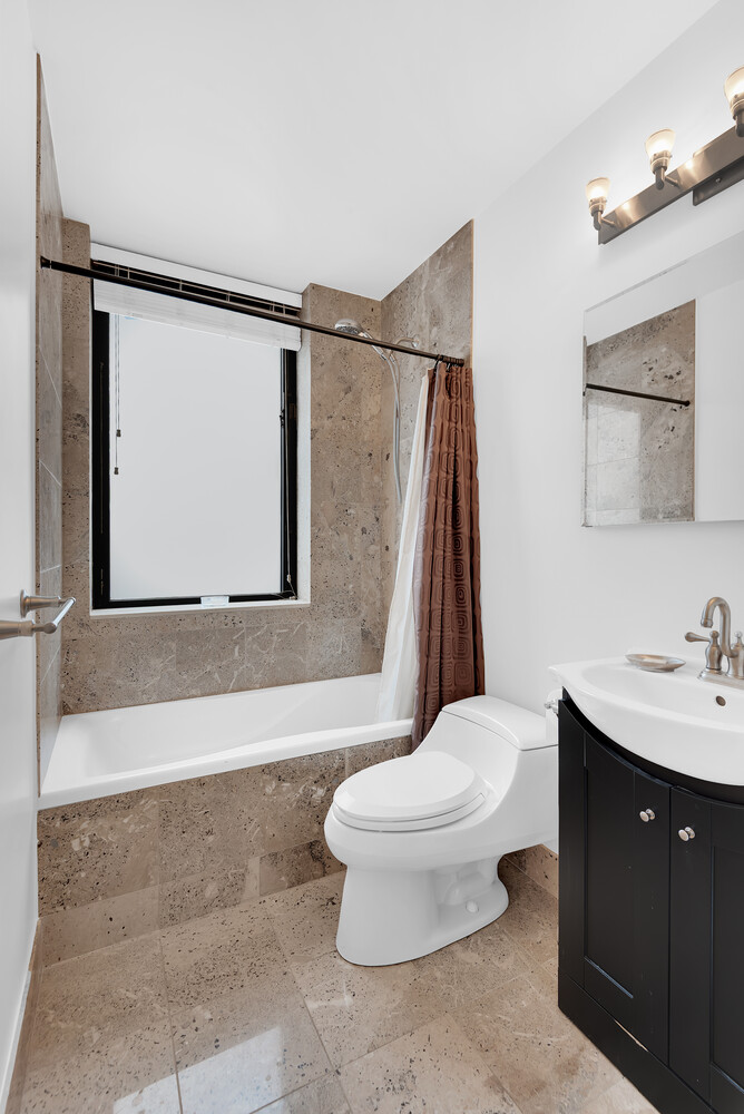 330 East 75th Street, Unit 4B Manhattan, NY 10021 - Photo 10 of 12 a bathroom with a toilet sink and mirror