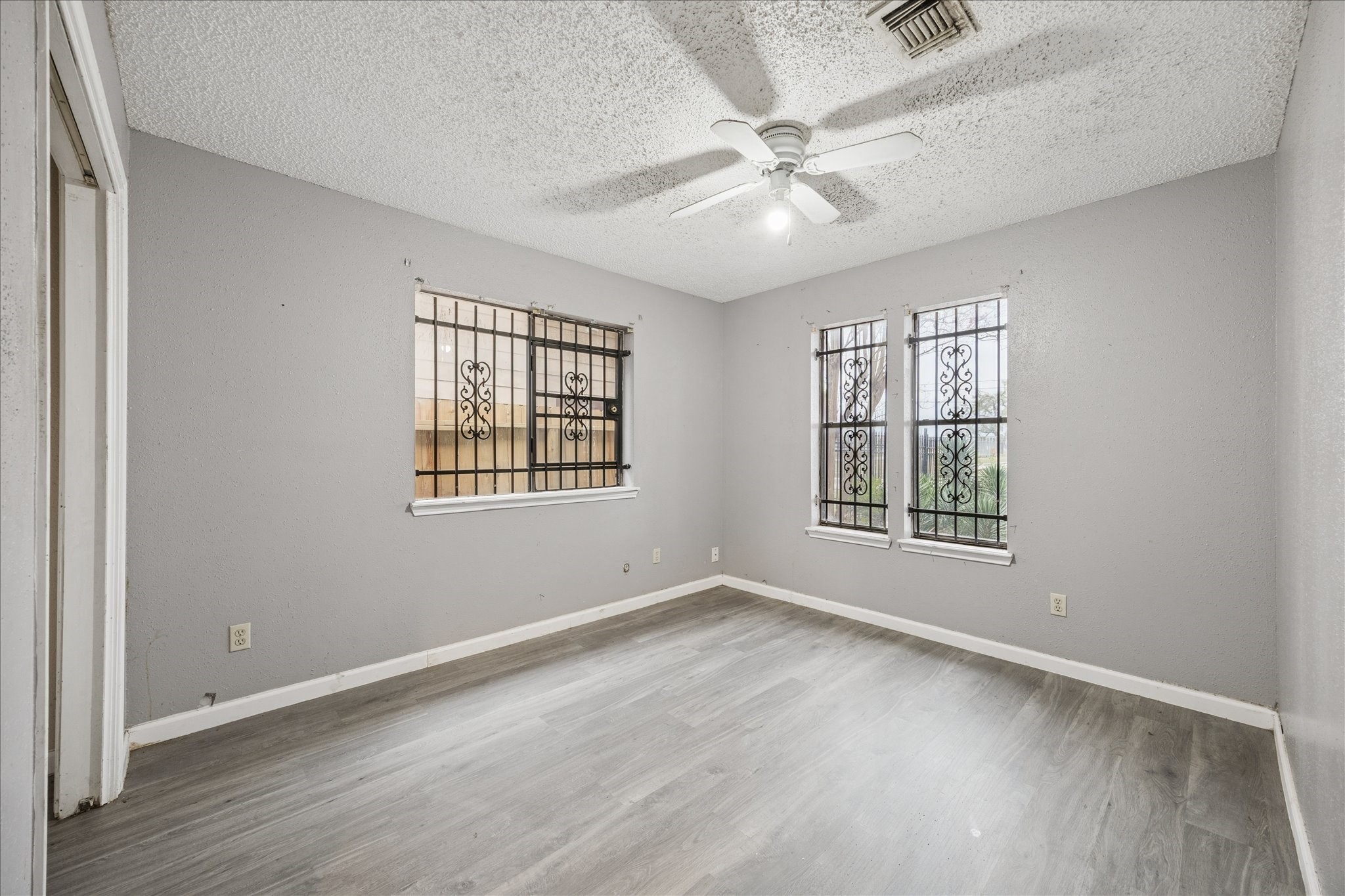 9910 Genard Road Houston, TX 77041 - Photo 11 of 15 an empty room with wooden floor fan and windows