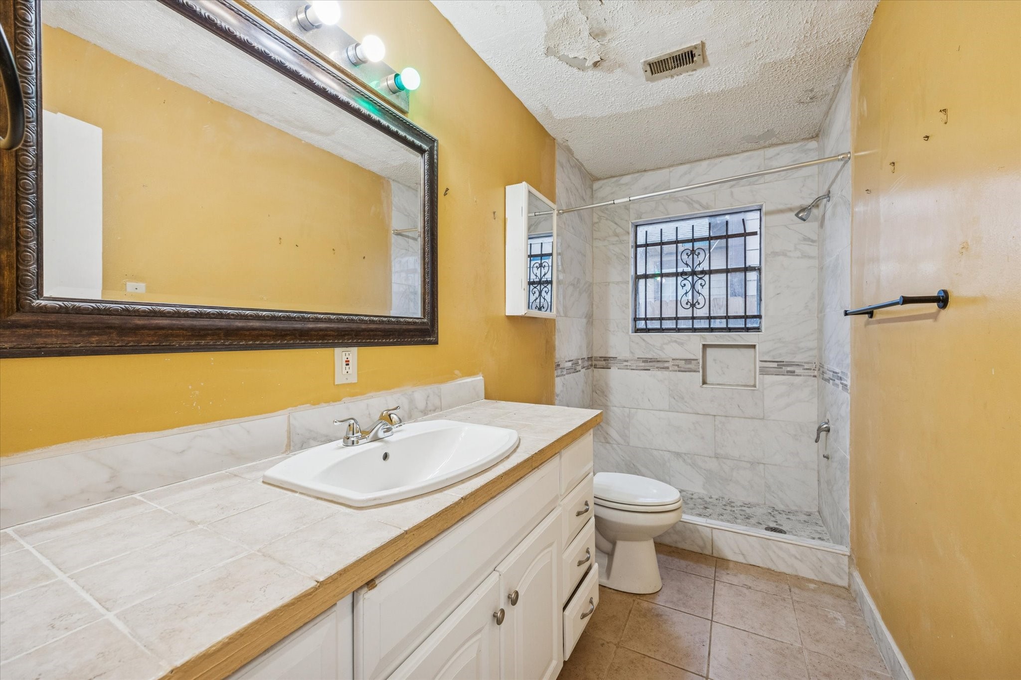 9910 Genard Road Houston, TX 77041 - Photo 13 of 15 a bathroom with a sink a toilet and a large mirror