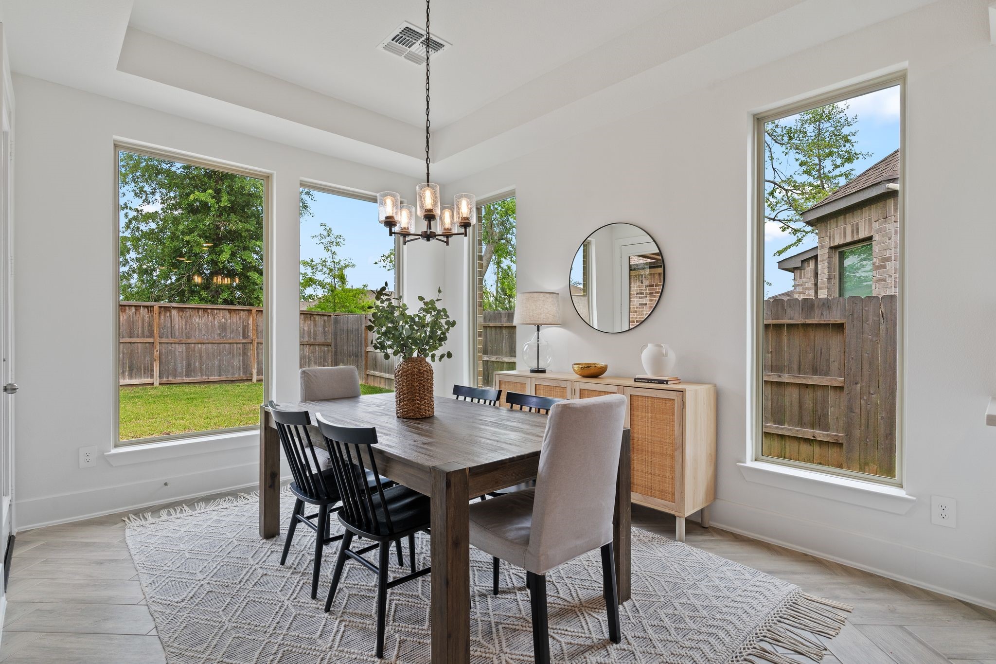 914 Sendero Trail Conroe, TX 77304 - Photo 14 of 47 Elegant dining area filled with natural light from the large window and features stylish modern chandelier create a welcoming space, perfect for hosting diner parties or everyday meals.
