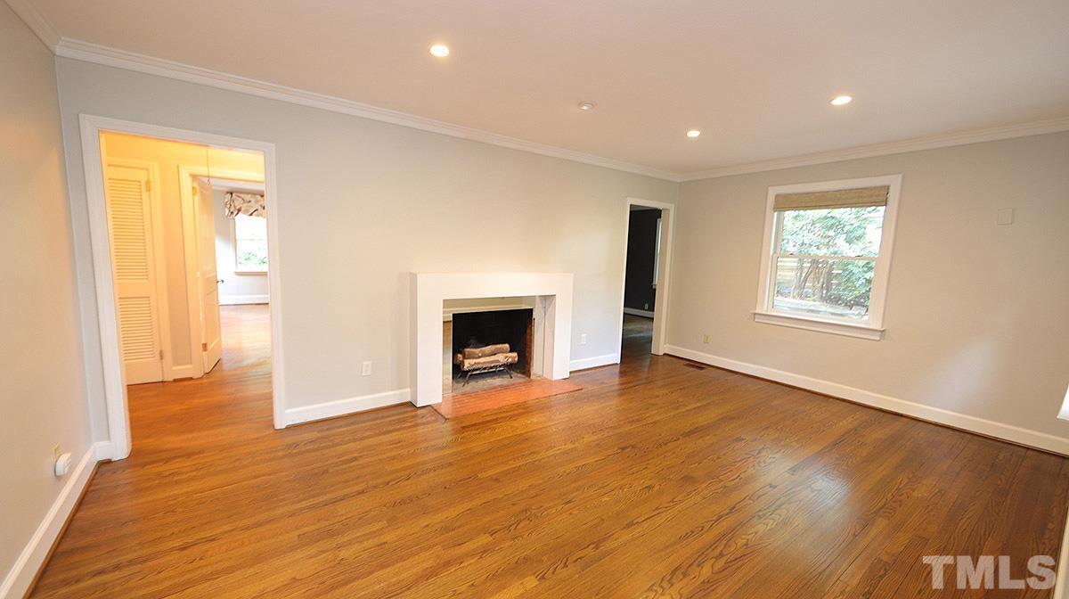 829 Runnymede Road Raleigh, NC 27607 - Photo 5 of 29 a view of an empty room with wooden floor and a window