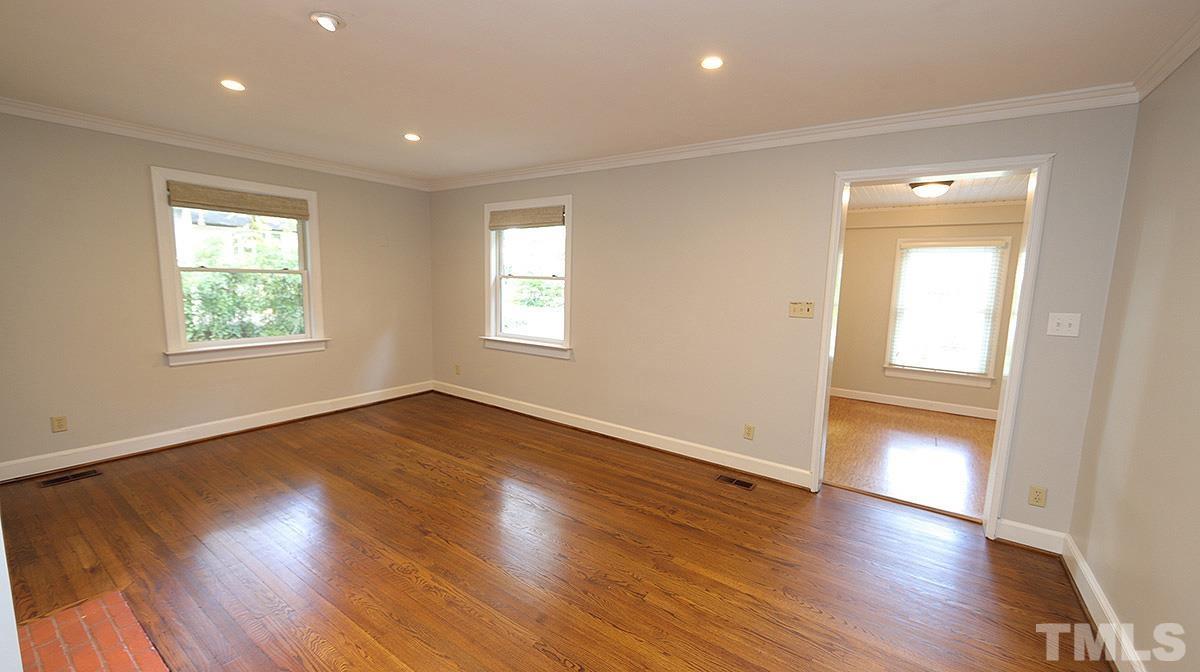 829 Runnymede Road Raleigh, NC 27607 - Photo 6 of 29 an empty room with wooden floor and windows
