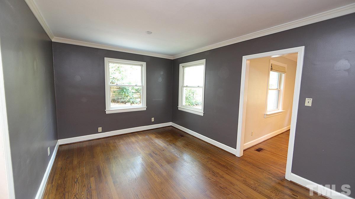 829 Runnymede Road Raleigh, NC 27607 - Photo 7 of 29 an empty room with wooden floor and windows
