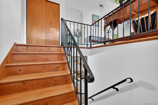a view of staircase with wooden floor and white walls