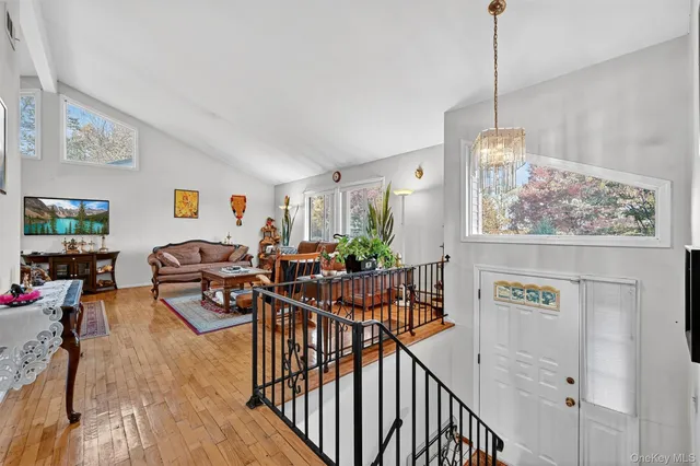 a view of a livingroom and dining room with furniture wooden floor and chandelier