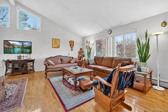 a living room with furniture a large window and a flat screen tv