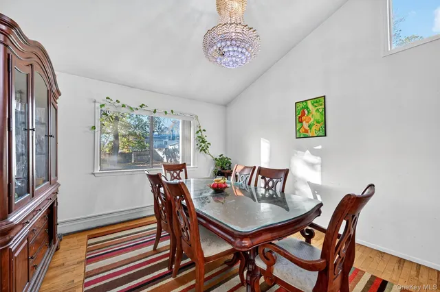 a view of a dining room with furniture a rug and wooden floor
