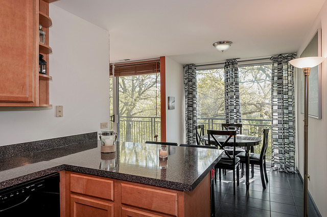 6017 Forest View Road, Unit 2C Lisle, IL 60532 - Photo 6 of 10 a kitchen with stainless steel appliances granite countertop wooden floor dining table and chairs