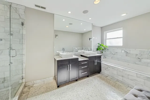 a spacious bathroom with a double vanity sink and a bathtub
