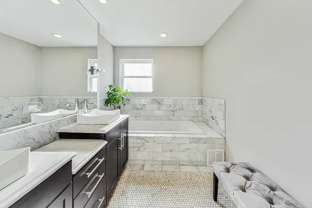 a spacious bathroom with a tub sink and mirror