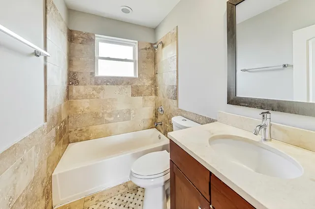 a bathroom with a sink toilet vanity and bathtub