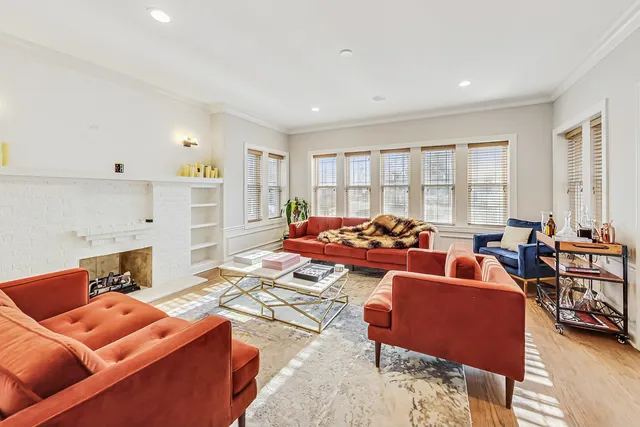 a living room with furniture a fireplace and wooden floor