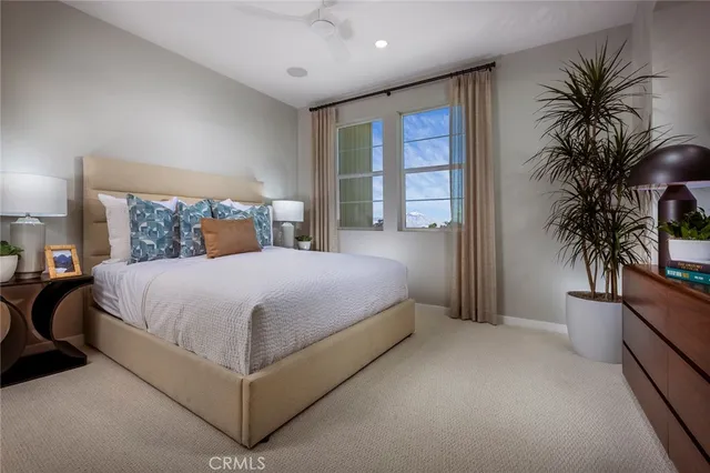 a bedroom with a large bed and a potted plant