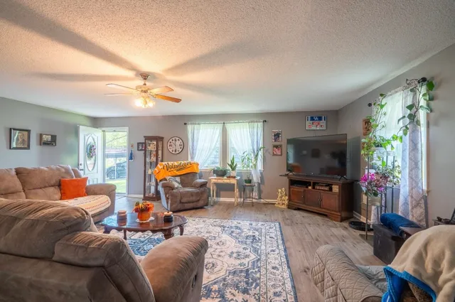 a living room with furniture a window and a flat screen tv