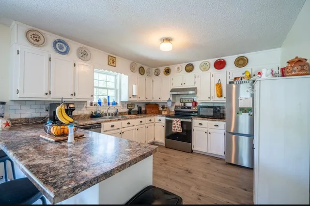 a kitchen with stainless steel appliances granite countertop a sink stove and refrigerator