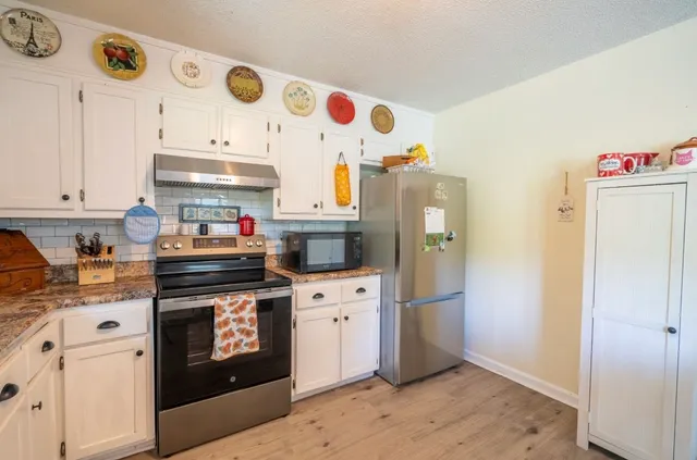 a kitchen with stainless steel appliances granite countertop a refrigerator and a stove