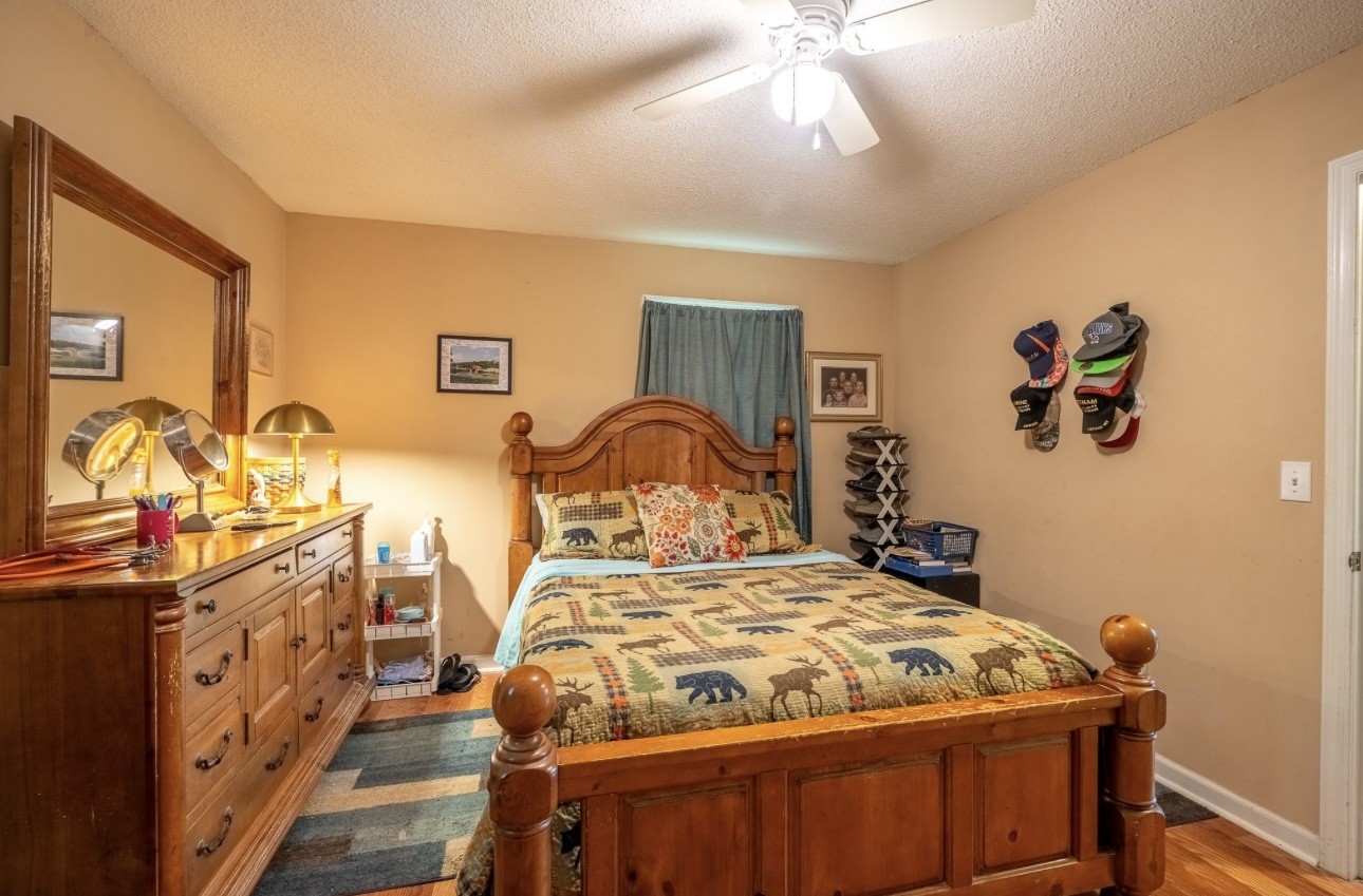 652 Old Florence Pulaski Road Leoma, TN 38468 - Photo 19 of 35 a bedroom with a bed and a chandelier