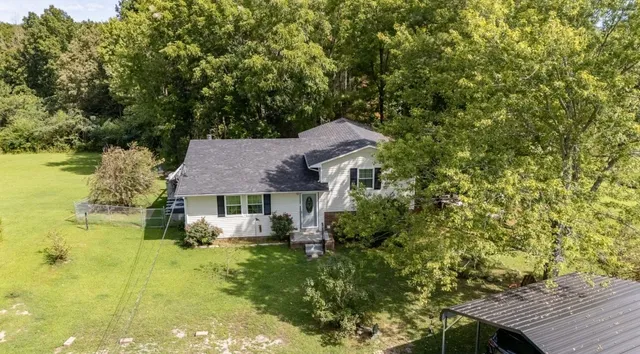 a aerial view of a house with swimming pool next to a yard