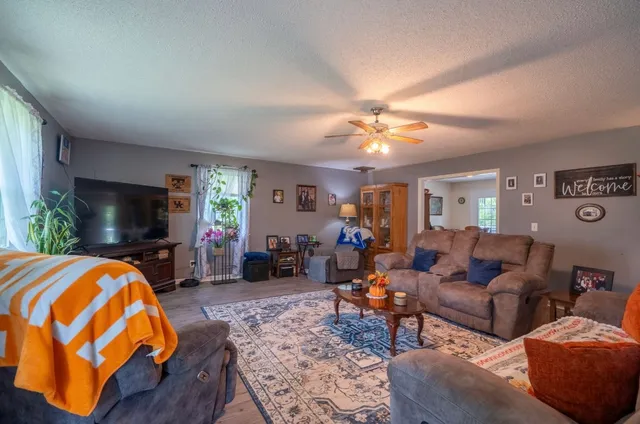 a living room with furniture a flat screen tv and a chandelier