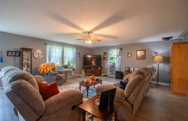 a living room with furniture a desk and chair with wooden floor