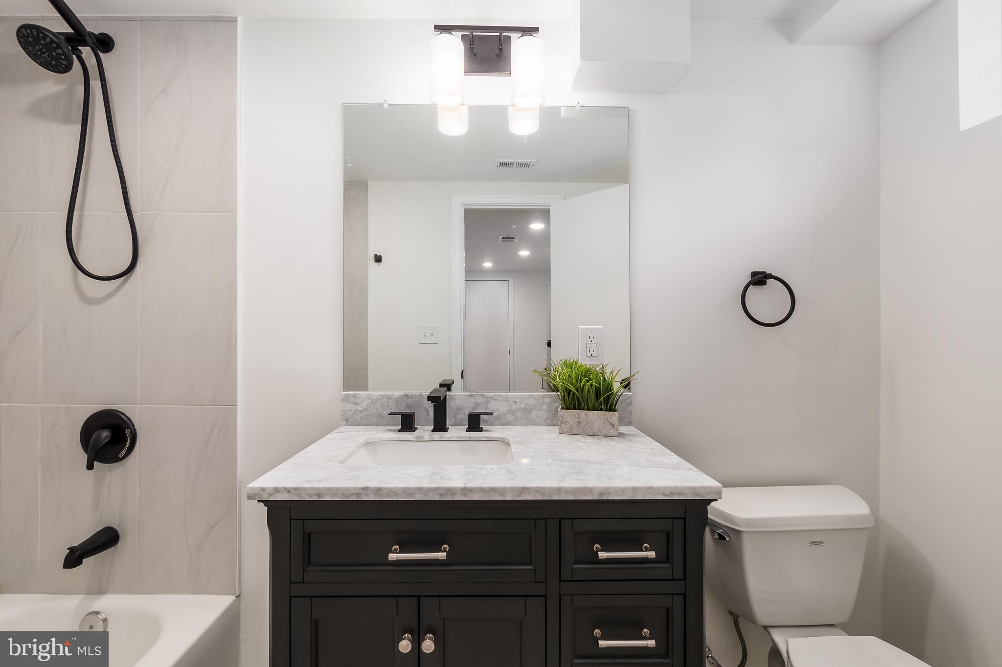 10319 Bethesda Church Road Damascus, MD 20872 - Photo 25 of 41 a bathroom with a granite countertop sink toilet and mirror