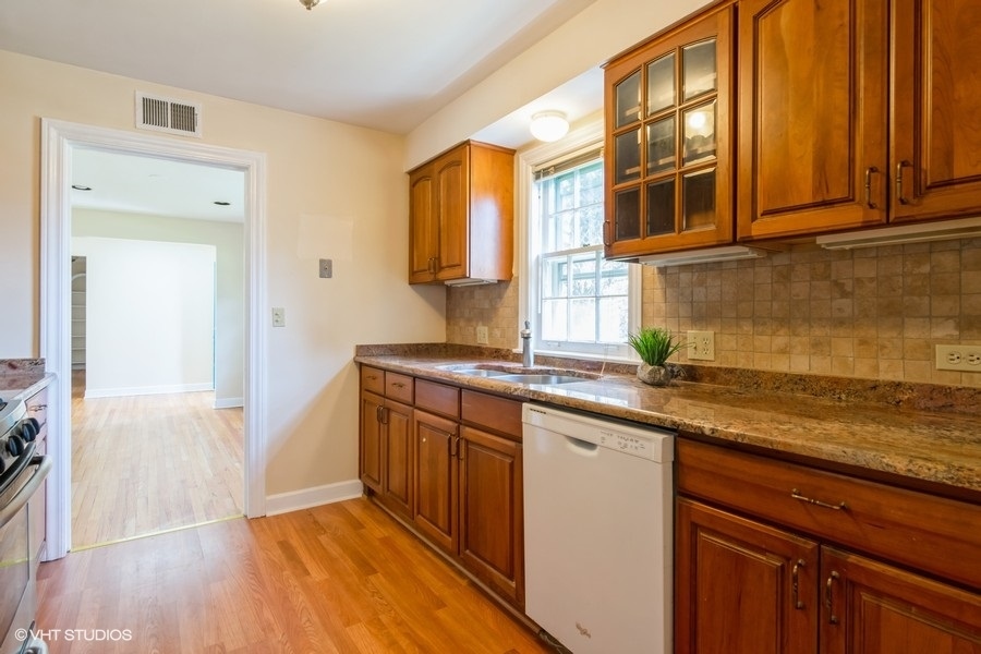 314 Wagner Road Northfield, IL 60093 - Photo 8 of 17 a kitchen with stainless steel appliances granite countertop a sink and dishwasher cabinets with wooden floor