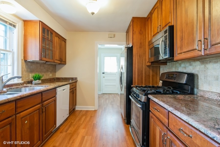 314 Wagner Road Northfield, IL 60093 - Photo 9 of 17 a kitchen with stainless steel appliances granite countertop a stove a sink and a microwave