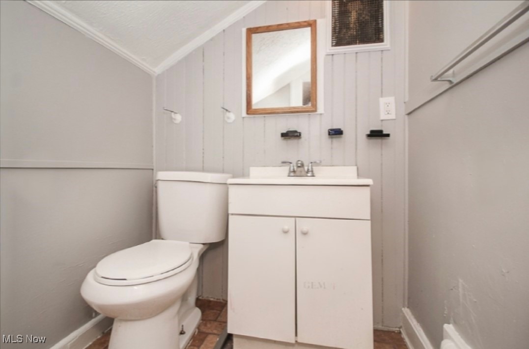 3397 Silsby Road Cleveland, OH 44118 - Photo 11 of 12 Bathroom with vanity, lofted ceiling, toilet, and wood walls