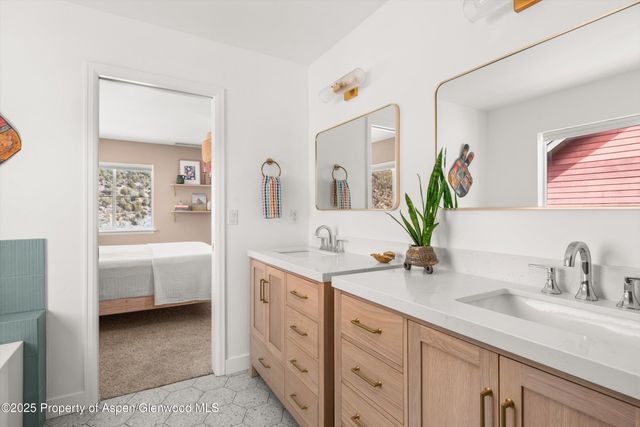 a spacious en suite bathroom with double sink and a mirror