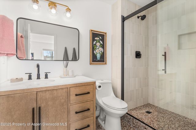 a bathroom with a granite countertop sink mirror vanity and toilet