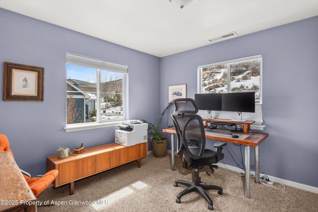 a view of a workspace with furniture and a window