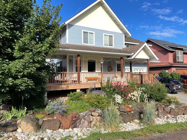 a front view of a house with a yard and potted plants