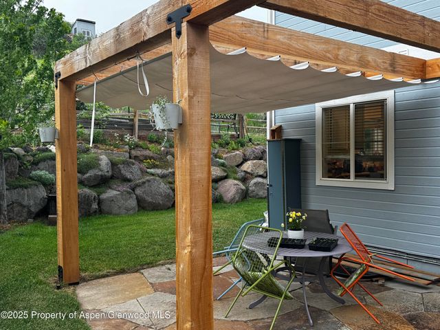 a view of backyard with a table and chairs and potted plants