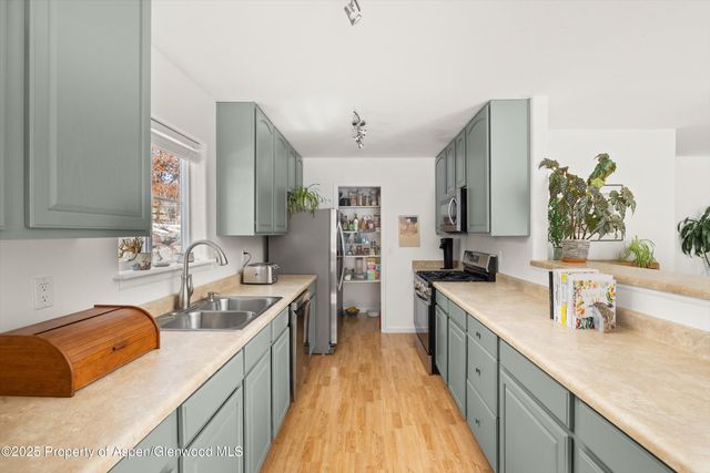 a kitchen with granite countertop a sink stove and cabinets
