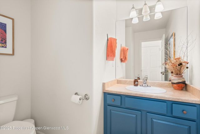 a bathroom with a sink vanity mirror and toilet