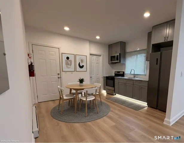 a kitchen with a refrigerator and a dining table
