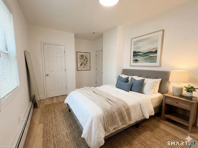 a bedroom with a bed and a painting on the wall