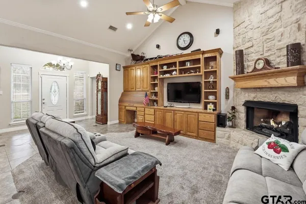 a living room with furniture a flat screen tv and a fireplace