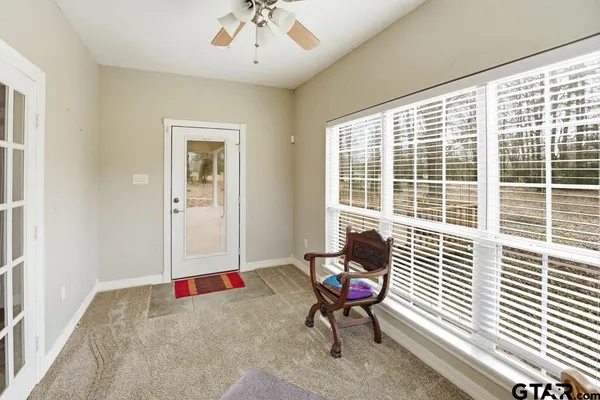 a view of a livingroom with lounge chair and windows