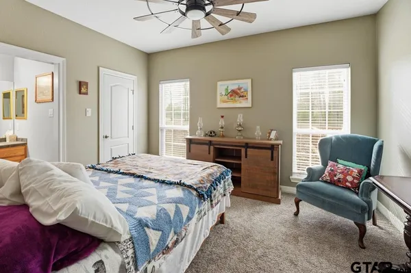 a living room with furniture a bookshelf and a window